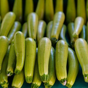 a bunch of green cucumbers sitting next to each other