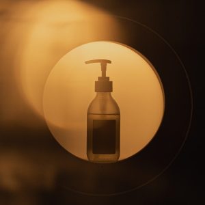 Hand sanitizer bottle glowing in a circular light.